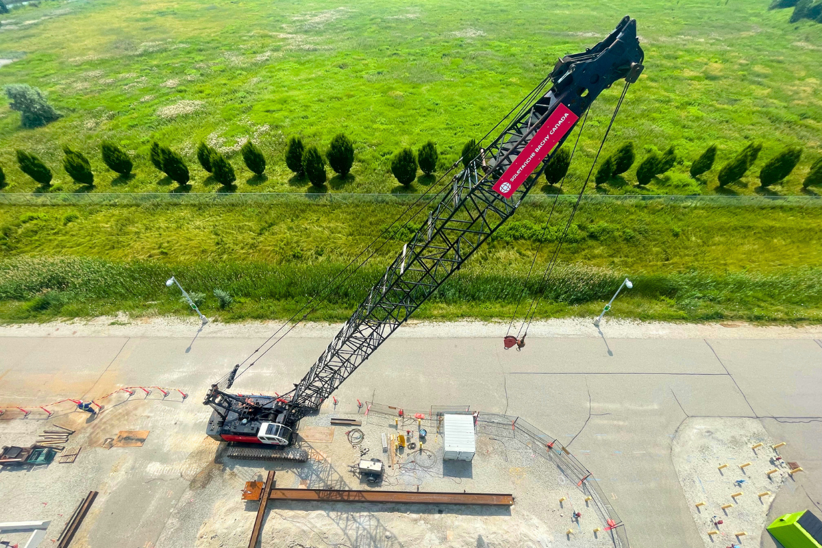 SBC crane from above next to a green field