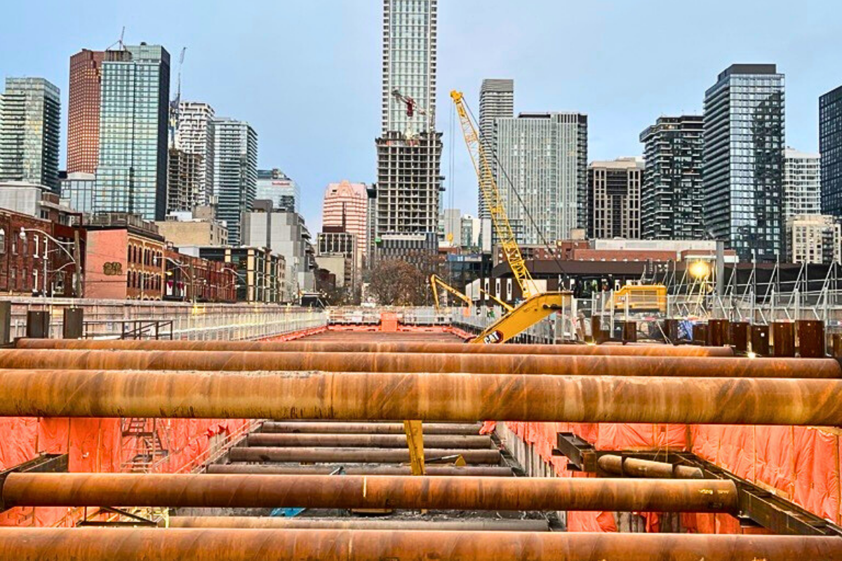 Toronto metro line jobsite with horizontal piles and buildings in the background