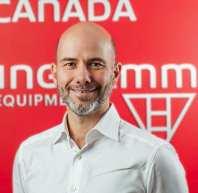 Photo of Balazs Gombos in SBC's office with a red background and the Soletanche Bachy Canada and Berminghammer logos