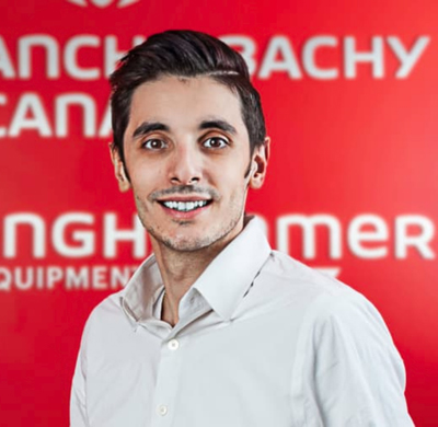 Photo of Christopher Fimiani in SBC's office with a red background and the Soletanche Bachy Canada and Berminghammer logos