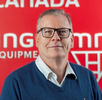 Photo of Scott Kelly in SBC's office with a red background and the Soletanche Bachy Canada and Berminghammer logos