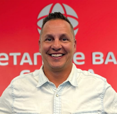 Photo of Shawn Jungwirth in SBC's office with a red background and the Soletanche Bachy Canada and Berminghammer logos