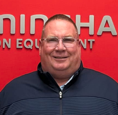Photo of Timothy Biggs in SBC's office with a red background and the Soletanche Bachy Canada and Berminghammer logos