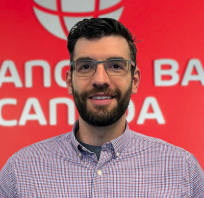 Photo of Jamie Sparkes in SBC's office with a red background and the Soletanche Bachy Canada and Berminghammer logos