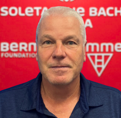 Photo of Luca Costa in SBC's office with a red background and the Soletanche Bachy Canada and Berminghammer logos