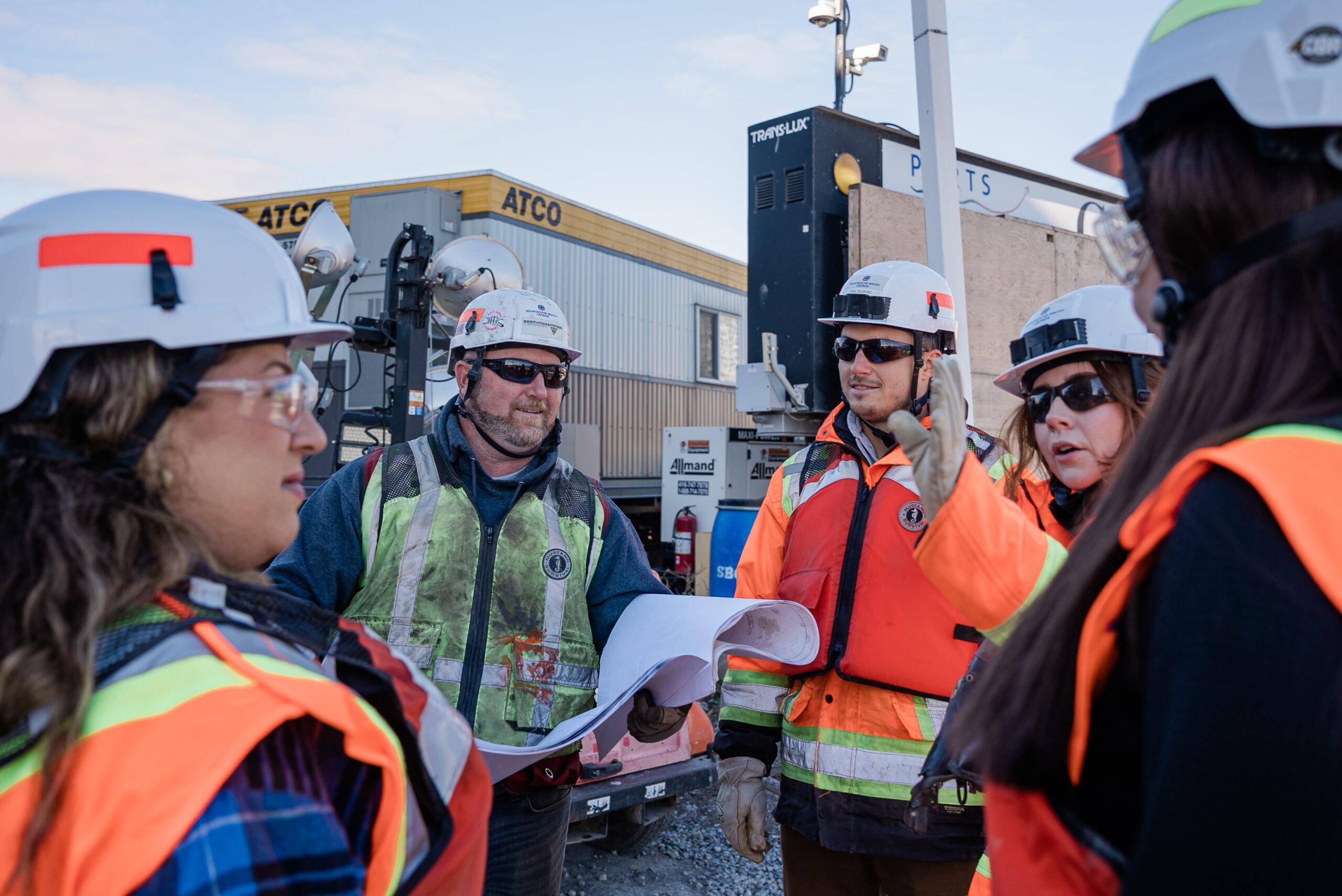 Build on us – Soletanche Bachy Canada a team of men and women having a debrief session on the jobsite