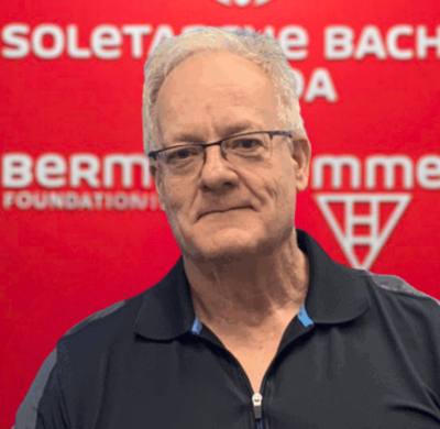 Photo of Michael-Gillies in SBC's office with a red background and the Soletanche Bachy Canada and Berminghammer logos