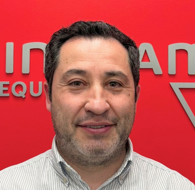 Photo of Edwin Gomez in SBC's office with a red background and the Soletanche Bachy Canada and Berminghammer logos